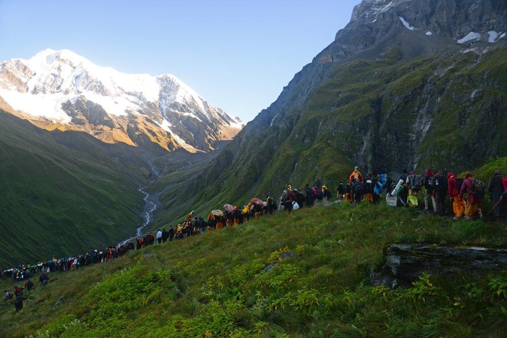 Pilgrims walking through the changing Himalayan landscape of the Nanda Devi Raj Jaat Yatra, from lower village routes to high-altitude mountain terrain.